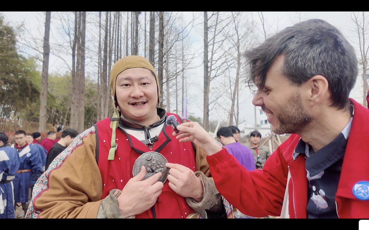 A Chinese buhurt fighter shows off a gift from an American peer