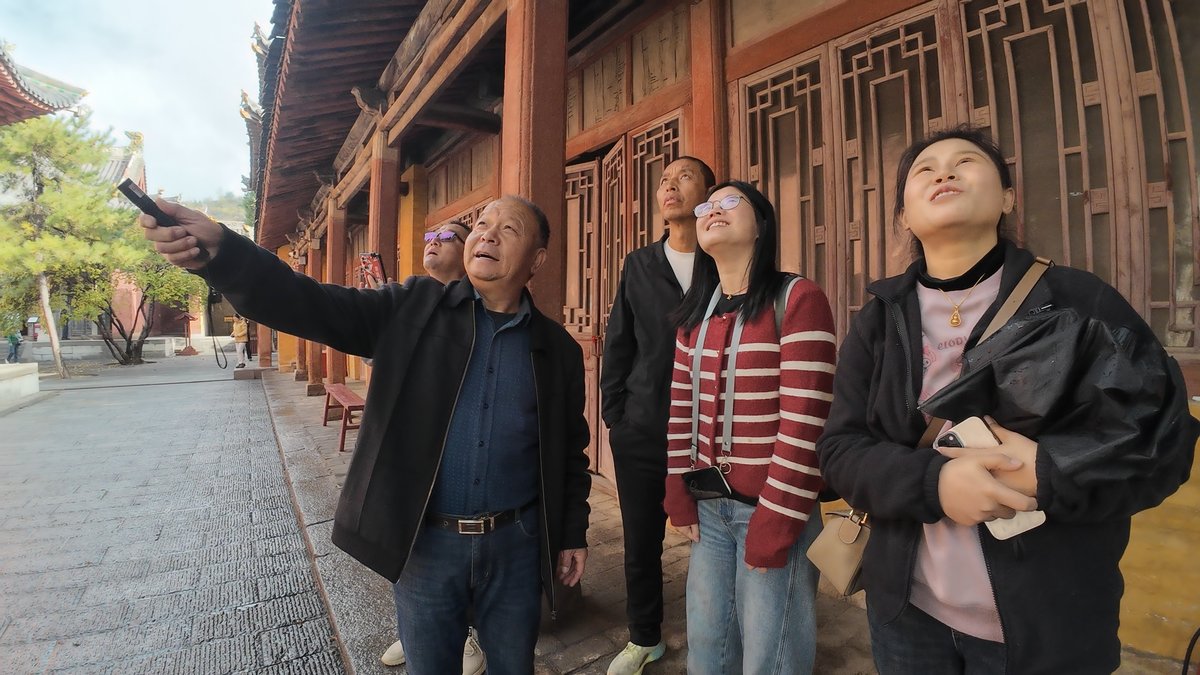 Xu Longfu, a 69-year-old temple keeper, guides tourists to identify12 Chinese zodiac animals on the trees