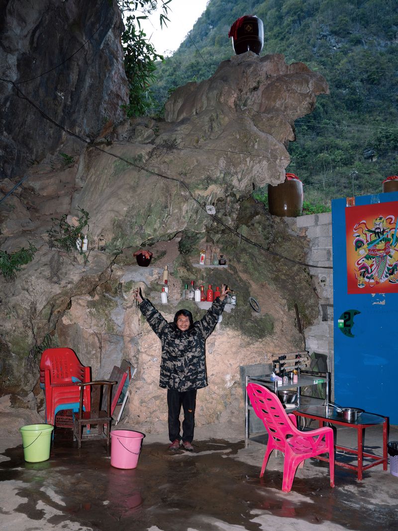 A man who lives and works in the cave is posing for a photo inside the cave