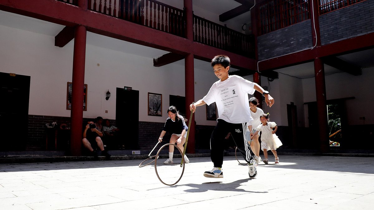 Young children playing with metal rings in Guangxi, pastime from older Chinese generations