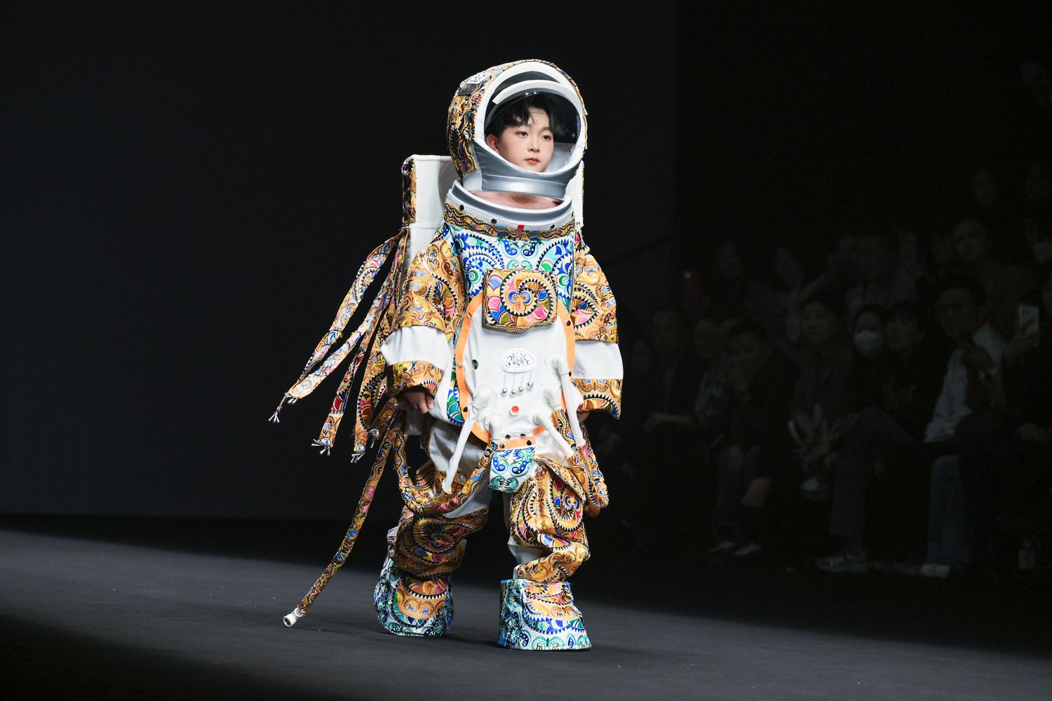 “Little T,” the astronaut-themed mascot of the ethnic village show featuring a spacesuit with Miao ethnic embroidery, walks on the stage of China Fashion Week this March