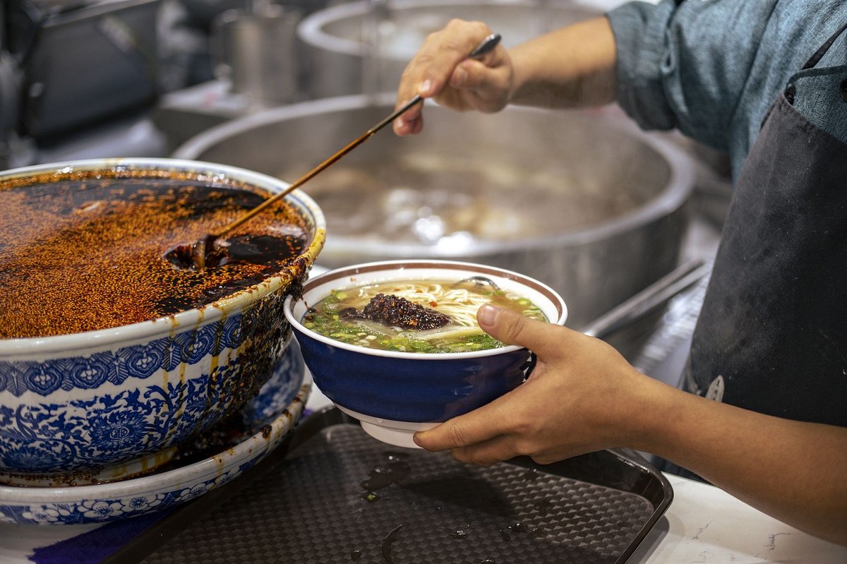 Spicy chili oil, chopped spring onions, and cilantro are added at the end to give the broth an extra layer of flavor