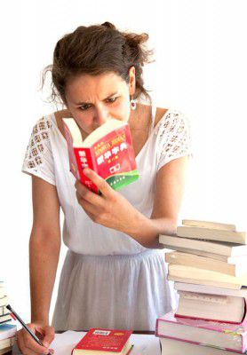 A girl pours over her Chinese dictionary to find the word she's looking for.