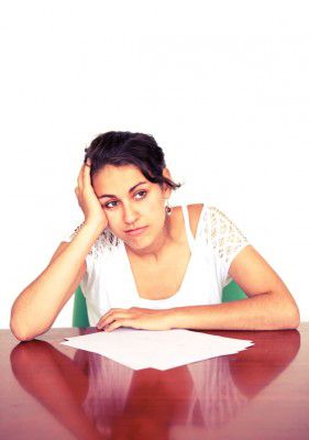 A girl sits exasperatedly at a desk.