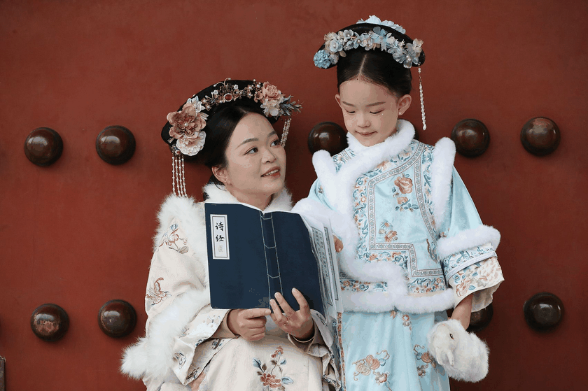 A mother and daughter in traditional costum reading the Classic of Poetry together