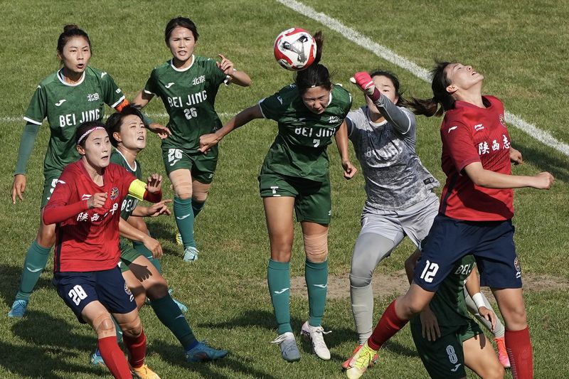 female soccer players fight for the ball