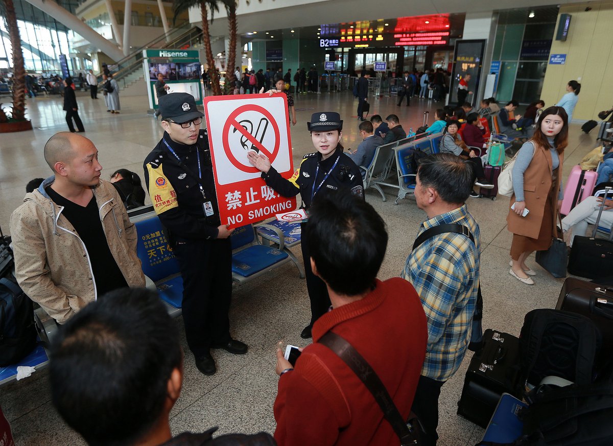 Chinese officials educating passengers against smoking on high-speed trains (VCG)