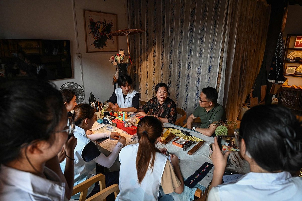 A fellow inheritor, He Yuejuan, discusses Nüshu with university students at a local workshop in Jiangyong, Nüshu script