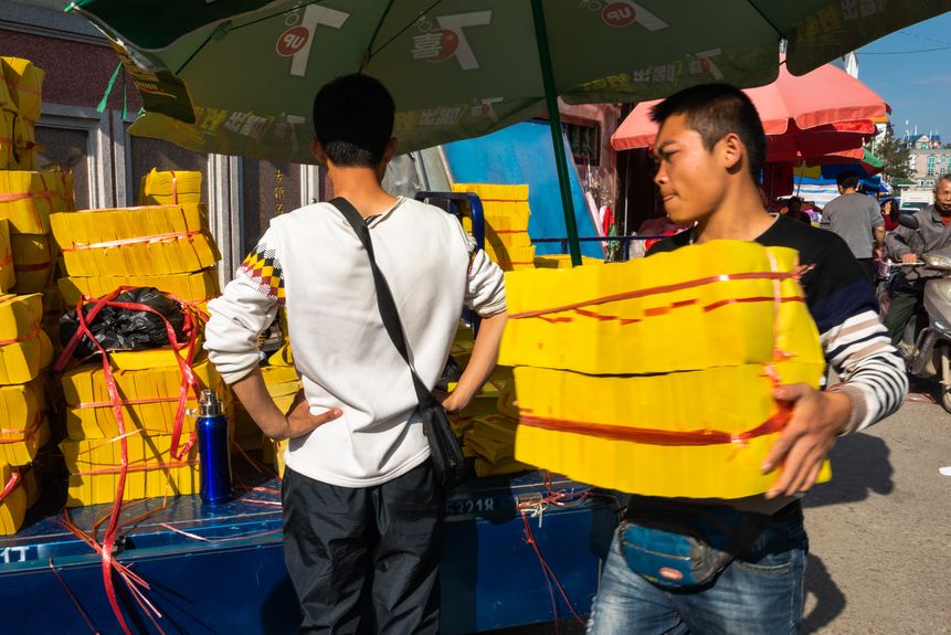 In Mianhu Town, Guangdong province, workers load their truck with “ghost money,” yellow paper that traditionally burnt as an offering to one’s ancestors (2016)