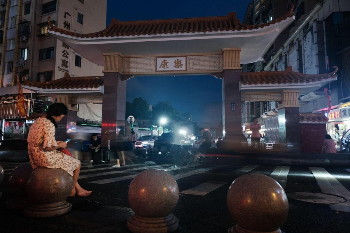 A woman sits on the stone pier at the entrance of Kangle village in Guangzhou, June 8, 2023