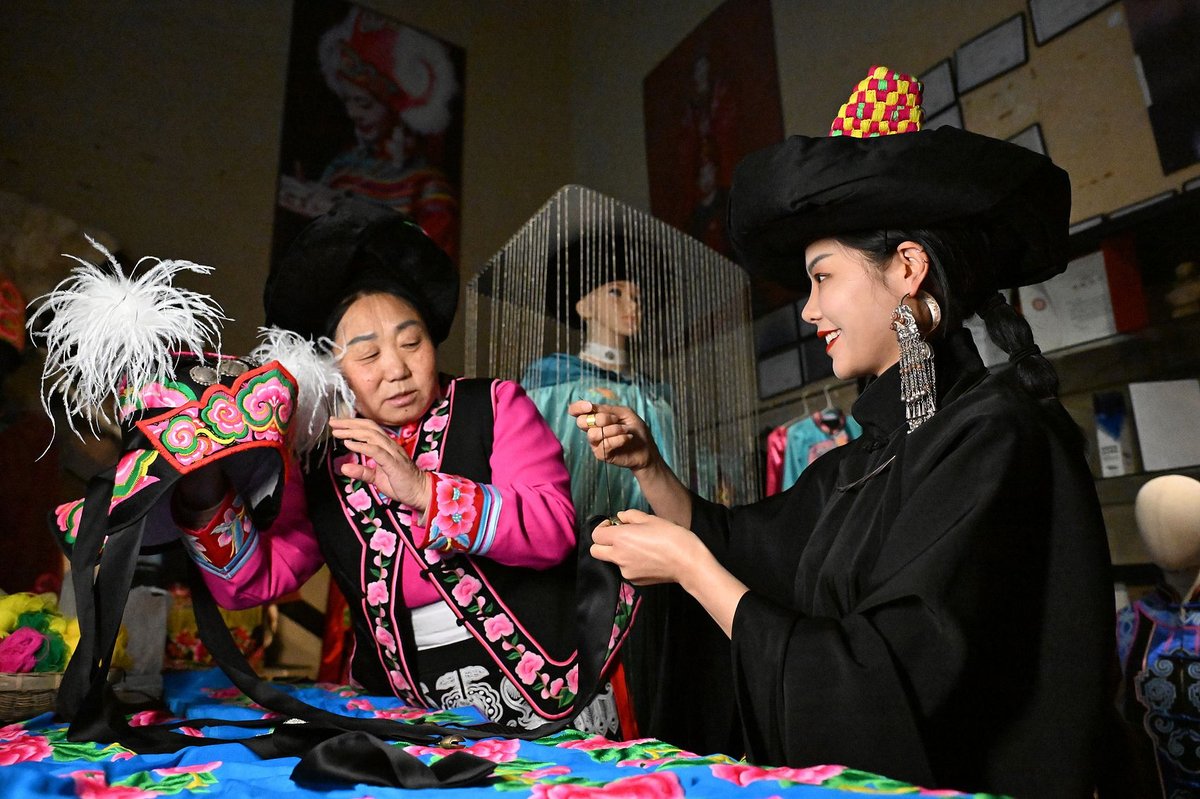 The fourth-generation inheritor of the traditional costume of the Qiang ethnic group, Chen Shijian (right), is dedicated to interpreting tradition with modern designs