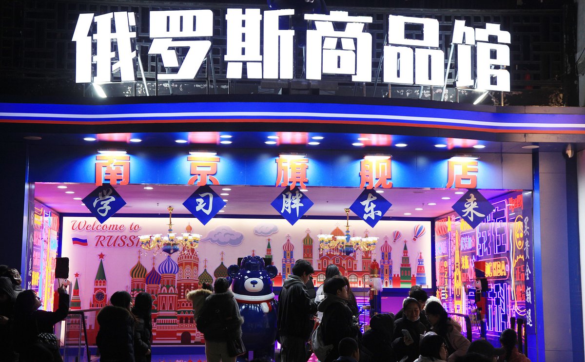 Tourists pass by a Russian shop in Nanjing