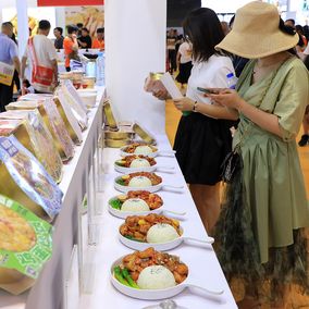 Shanghai pre-made food exhibit attendees trying food