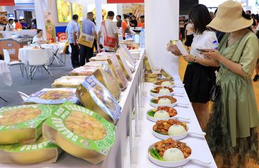 Shanghai pre-made food exhibit attendees trying food
