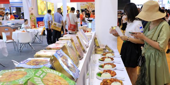 Shanghai pre-made food exhibit attendees trying food