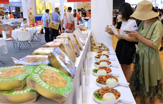 Shanghai pre-made food exhibit attendees trying food
