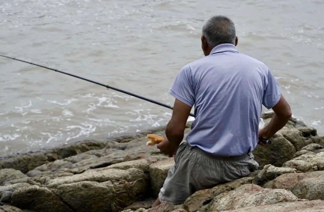 Islander eating a snack while fishing