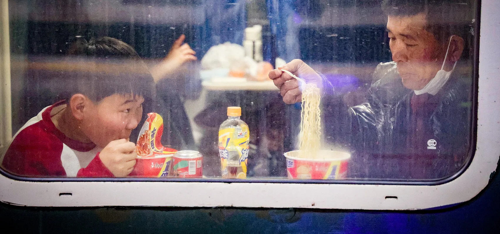 Spring Festival 2025_travelers eating instant noodles train_VCG111542124462