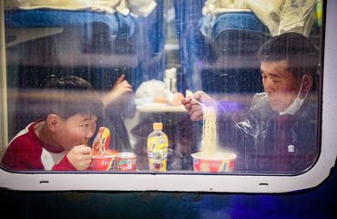 Spring Festival 2025_travelers eating instant noodles train_VCG111542124462