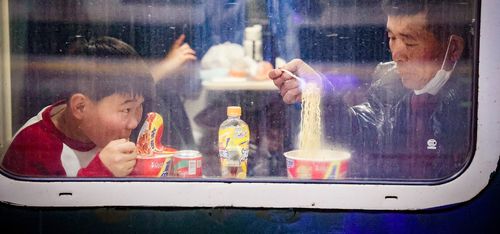 Spring Festival 2025_travelers eating instant noodles train_VCG111542124462