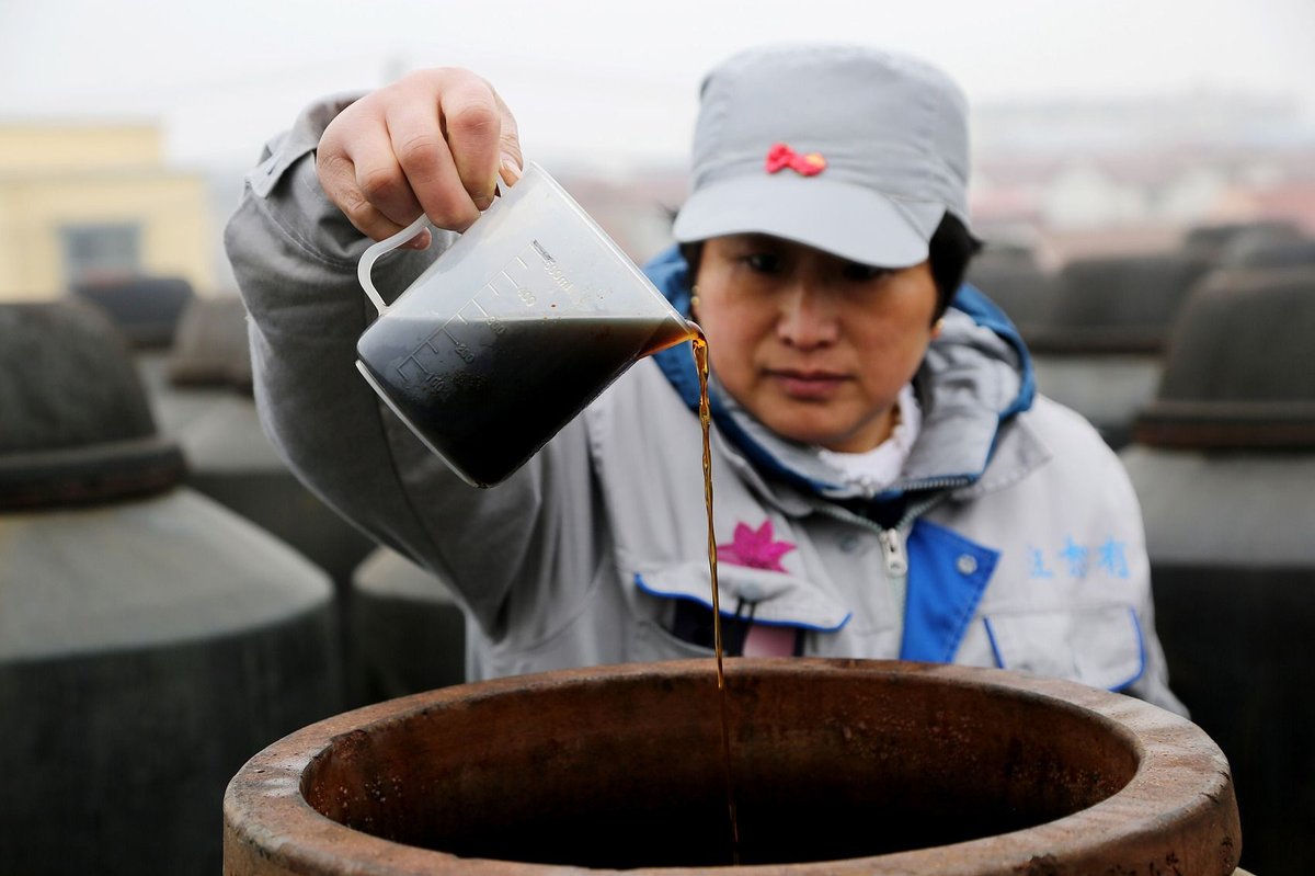 A worker checking the vinegar brewing status in a workshop in Lianyungang, Jiangsu
