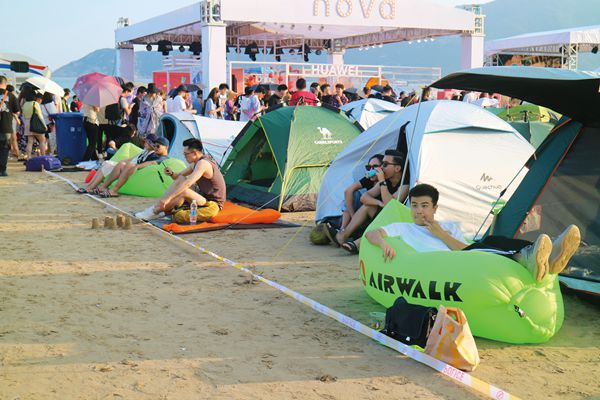 Musical festival attendees camping out and relaxing between shows.  