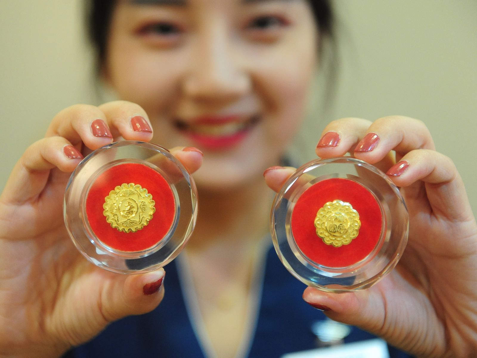 Young woman holding up gold jewelery