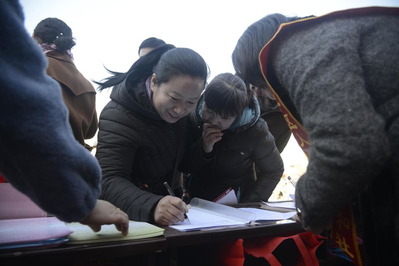 Women fill out applications to become yuesao and housekeepers at a job fair for migrant workers in Hohhot
