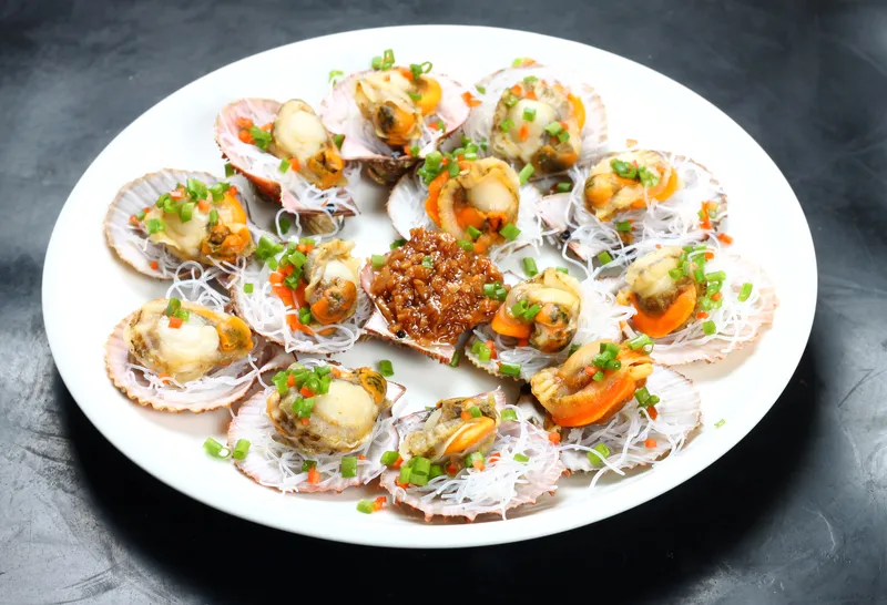 A Chinese new year dinner includes Guangdong's steamed scallops with garlic and vermicelli