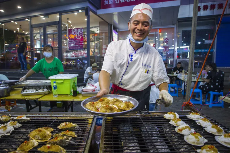 A man grilling seafood in Jinzhou, Liaoning