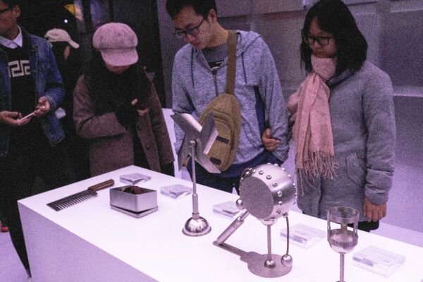 Chinese visitors examining pieces of art from the "Handmade" gallery by Cheng Mingqiang. 