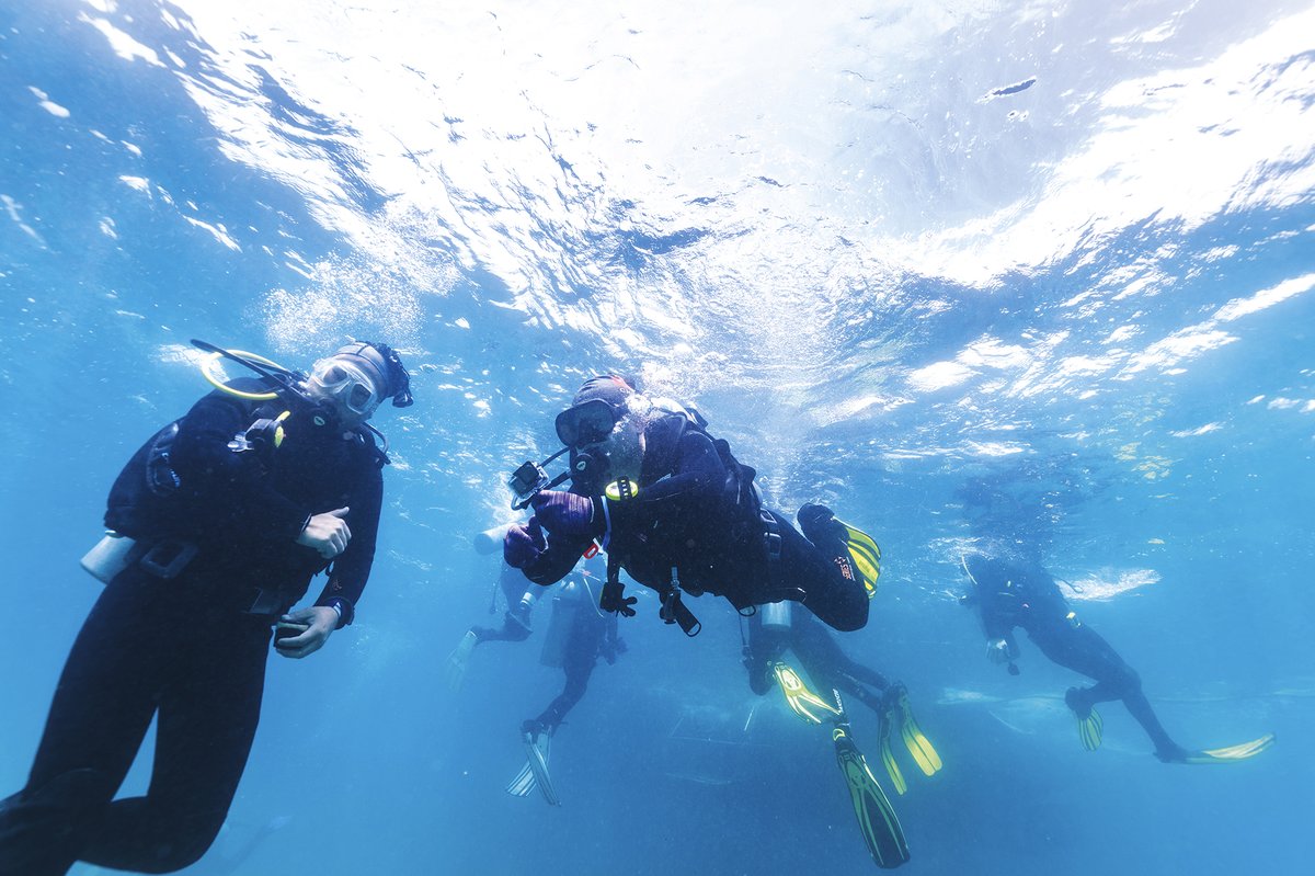 A tourist in Hainan taking a diving lesson from a coach