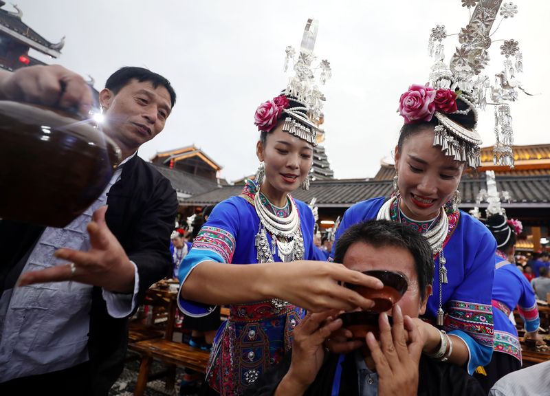 Guests and tourists are fed alcohol at a traditional celebration of the Dong people hosted in the Guangxi region.