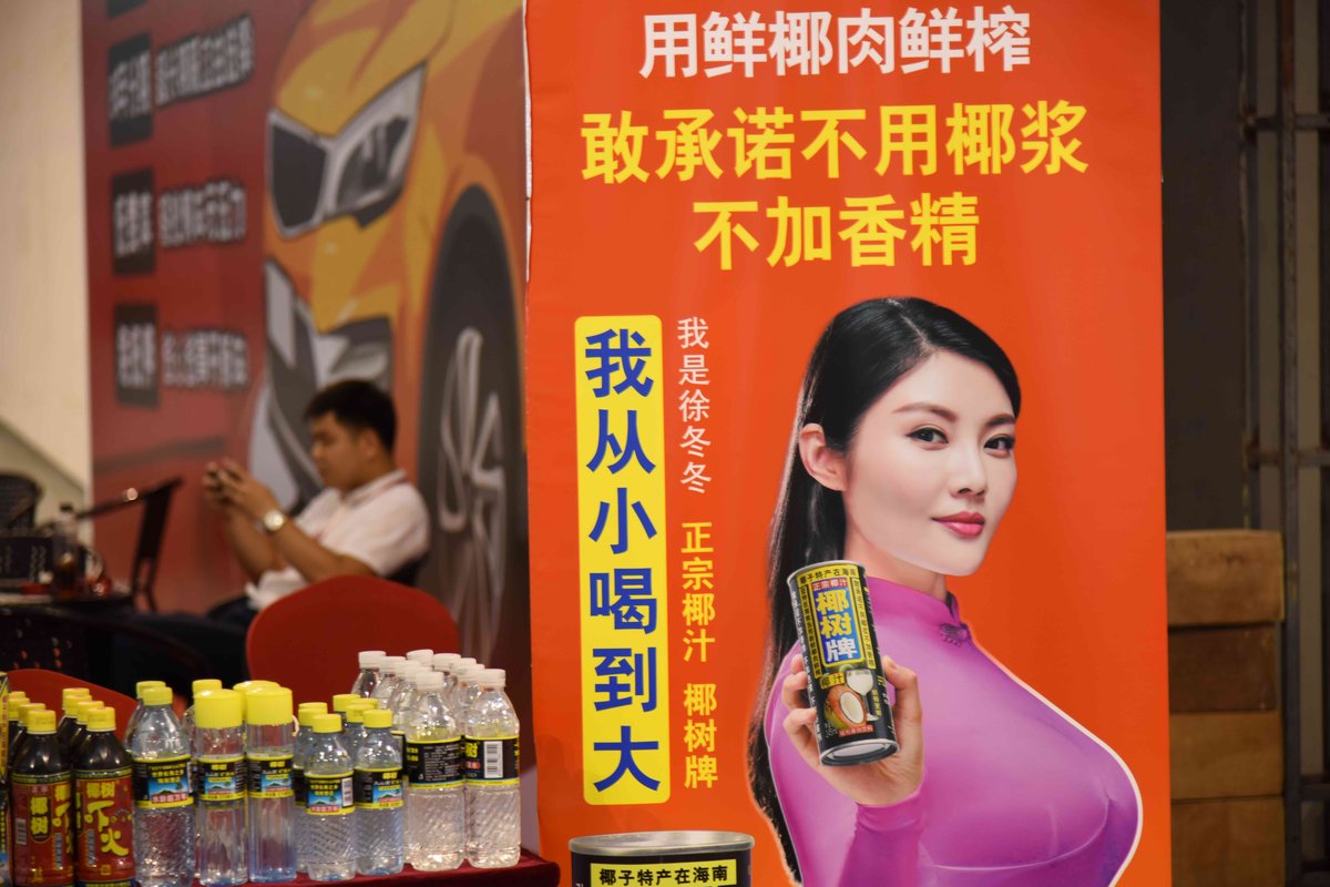 curvy model in pink skintight top holding coconut palm drink red poster