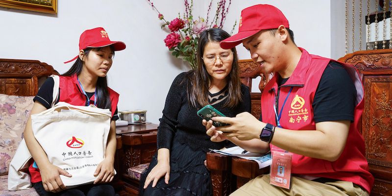 Two Chinese census bureau officials talking with a Chinese resident