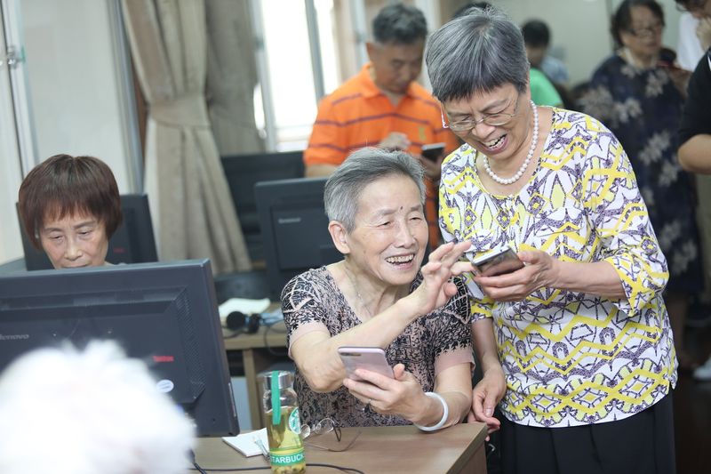 Elderly people having mobile phone-related courses at a university for the seniors (VCG)