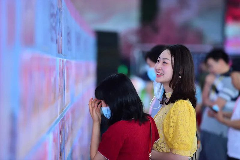 A young woman checks out the personal details of attendees of a high-end dating event in Dongguan, Guangdong province