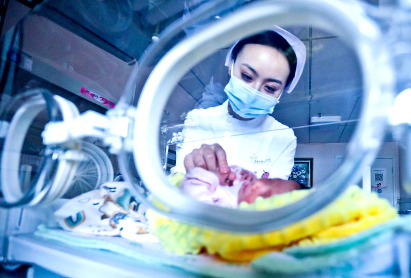 Nurse inspecting a newborn baby (VCG)