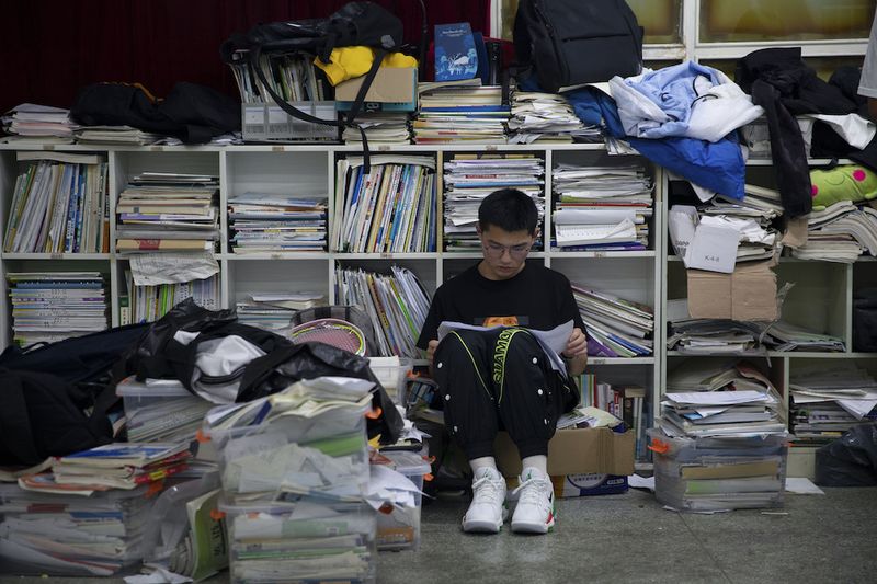 Behind Chinese Entrance Exams, a Chinese high school student cramming in studying before the gaokao
