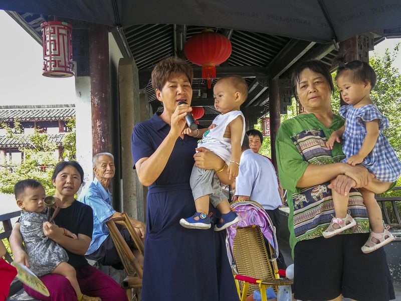 Nannies singing in a park while taking care of children in Yongkang, Zhejiang province