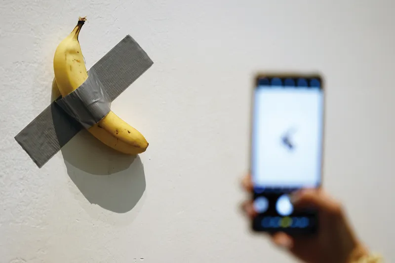 A visitor takes a photo of Maurizio Cattelan’s viral banana art “Comedian” during his exhibition in Beijing’s UCCA Center for Contemporary Art in 2021