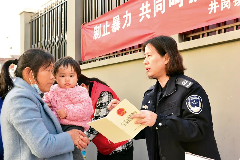 A Women’s Federation officer hands out anti-domestic violence pamphlets in Hefei, Anhui province