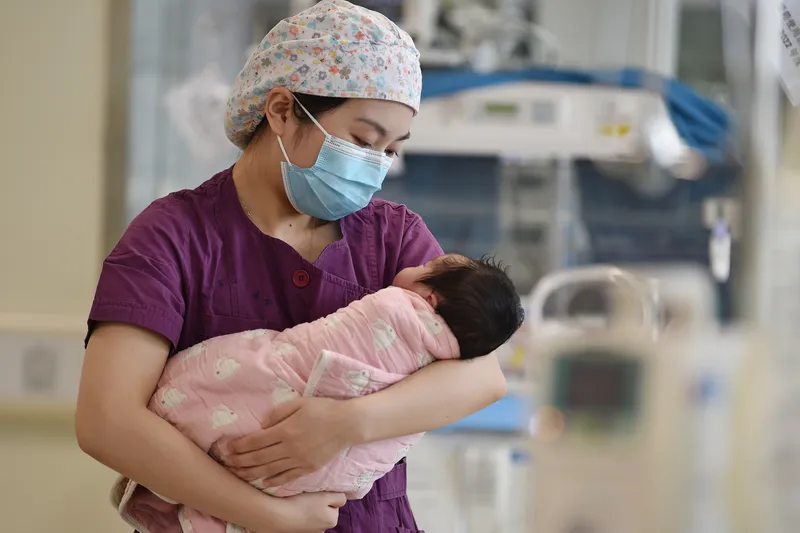 nurse holding new born baby