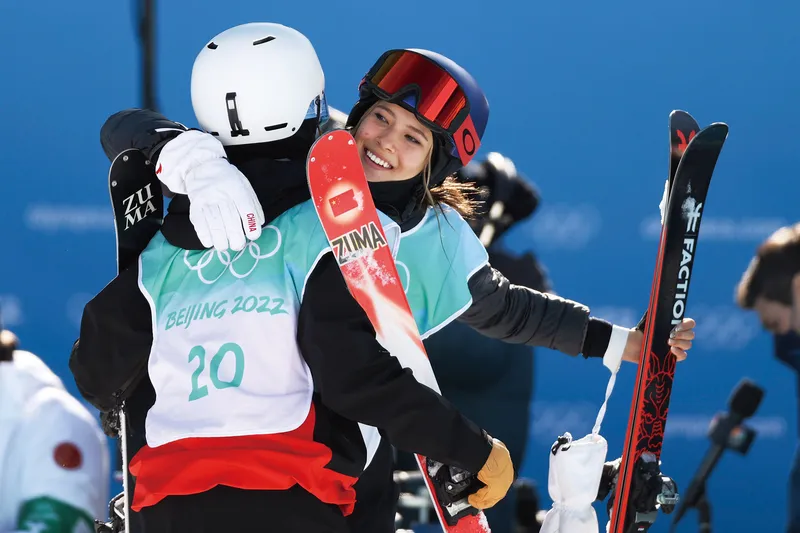 Gu Ailing, shown hugging a fellow competitor during the 2022 Winter Olympics, is one of the highest-profile naturalized athletes in recent years