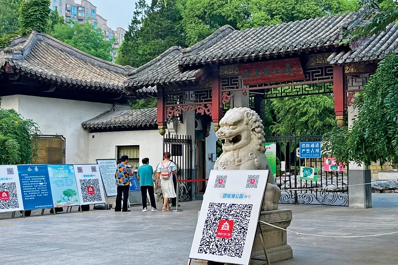 A sign with a QR code outside of Beijing’s Tuanjiehu Park: Visitors are expected to scan to register with their Health Kit upon entering, China’s digital hermits