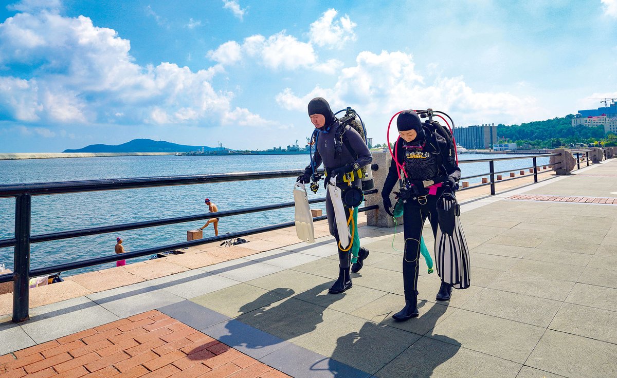 Divers walking along the coast in Weihai, Shandong province