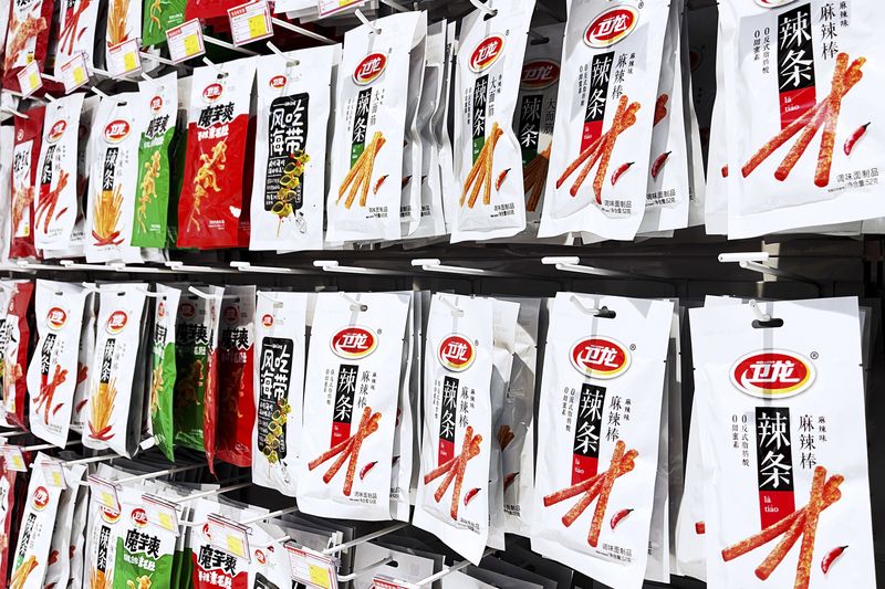 Rows of Weilong spicy strips, one of China's largest latiao manufacturers  line market shelves, latiao, Chinese snack