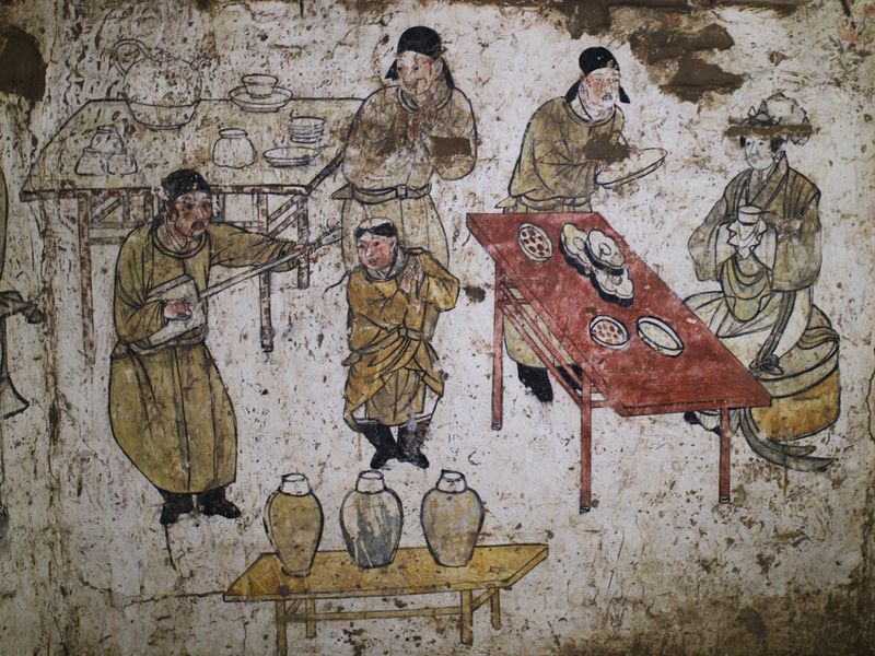 Wall painting in Han Shixun's tomb showing a gathering with servants serving and live performers.
