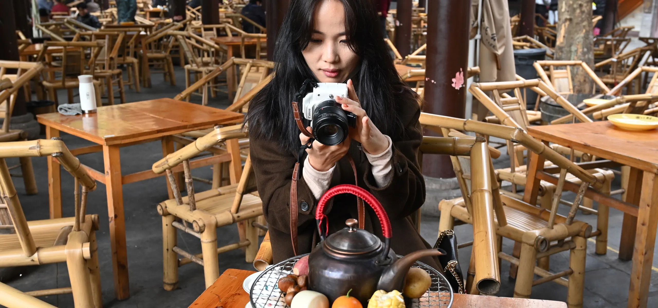 Young Chinese photographer taking photos of her tea