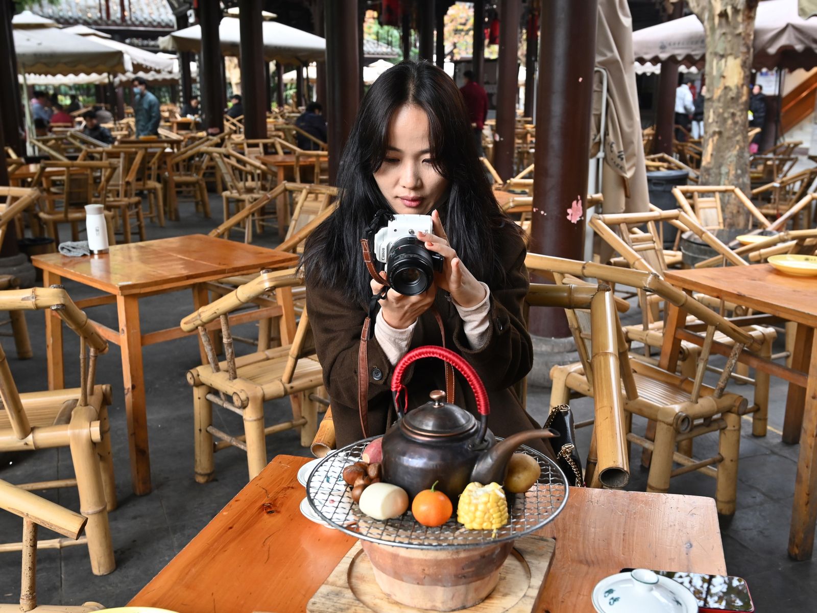 Young Chinese photographer taking photos of her tea